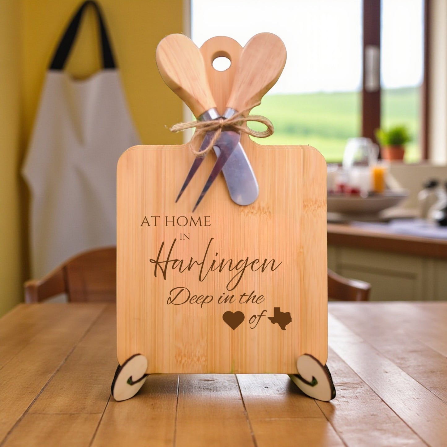Bamboo charcuterie board engraved with “At Home in Harlingen, Deep in the Heart of Texas” displayed in a kitchen setting.