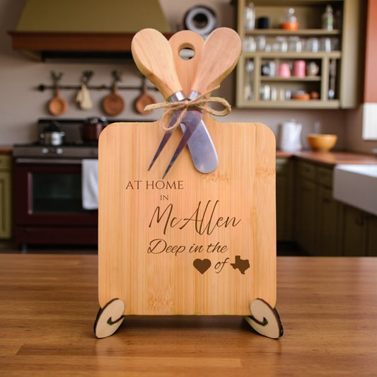 Bamboo charcuterie board engraved with “At Home in McAllen, Deep in the Heart of Texas” displayed on a modern kitchen countertop with utensils.