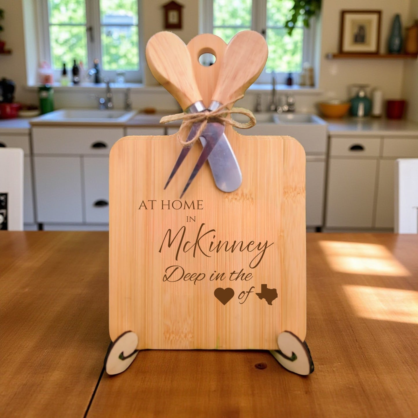 Bamboo charcuterie board engraved with “At Home in McKinney, Deep in the Heart of Texas” displayed in a kitchen setting.