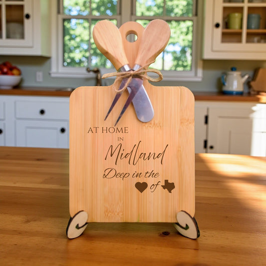 Bamboo charcuterie board engraved with “At Home in Midland, Deep in the Heart of Texas” displayed on a kitchen countertop with rustic accents.