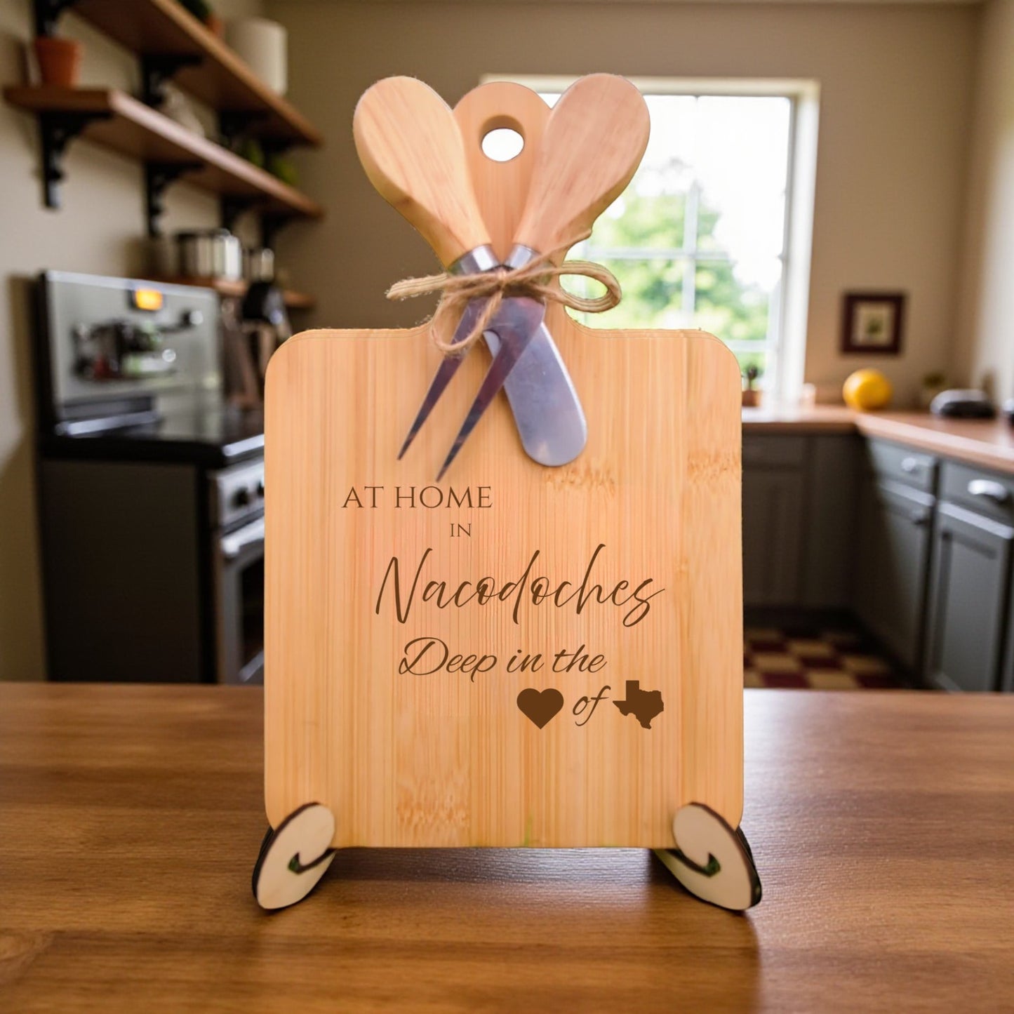 Bamboo charcuterie board engraved with “At Home in Nacogdoches, Deep in the Heart of Texas” displayed on a rustic table with kitchen décor.
