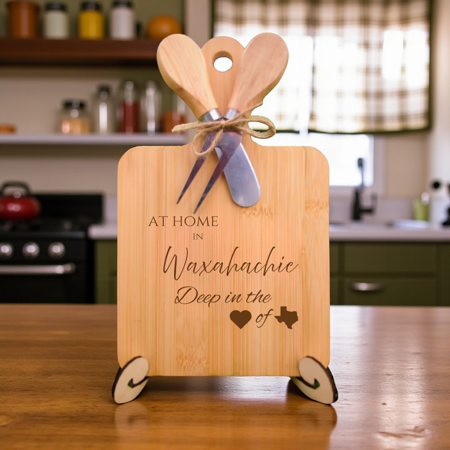 Bamboo charcuterie board engraved with “At Home in Waxahachie, Deep in the Heart of Texas” displayed in a kitchen setting.