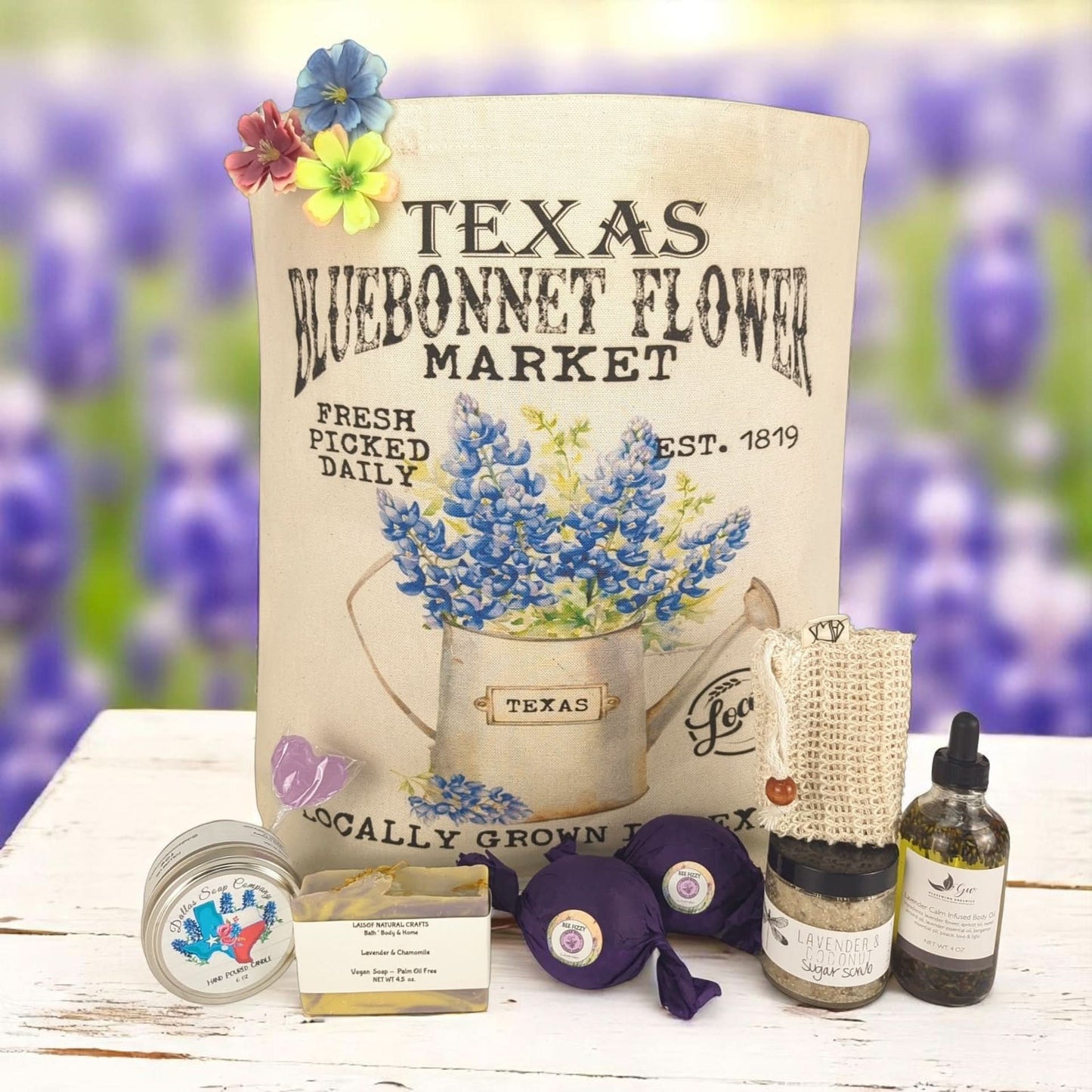 A variety of Texas-made products including food items and cosmetics, packaged in a tote bag with 'Texas Bluebonnet Flower Market' branding and Texas-made spa items