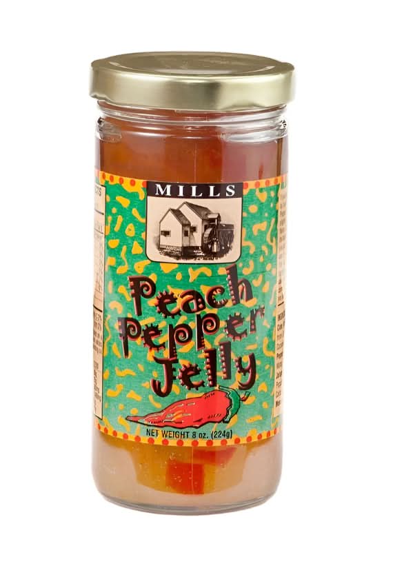 Mills Gourmet Peach Pepper Jelly in an 8 oz jar blending sweet peaches and spicy jalapeños, displayed on a rustic wooden surface as part of a Texas gift collection.