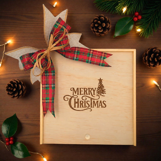 Create Your Own Merry Christmas Tree Wood Gift Box with a festive red plaid bow and "Merry Christmas" design, surrounded by pinecones, holly leaves, and holiday lights.