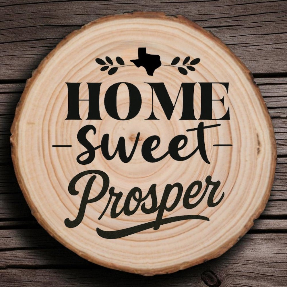 Rustic wood slice coaster with “Home Sweet Prosper” laser engraving, Texas silhouette, and leafy accents on wood background.