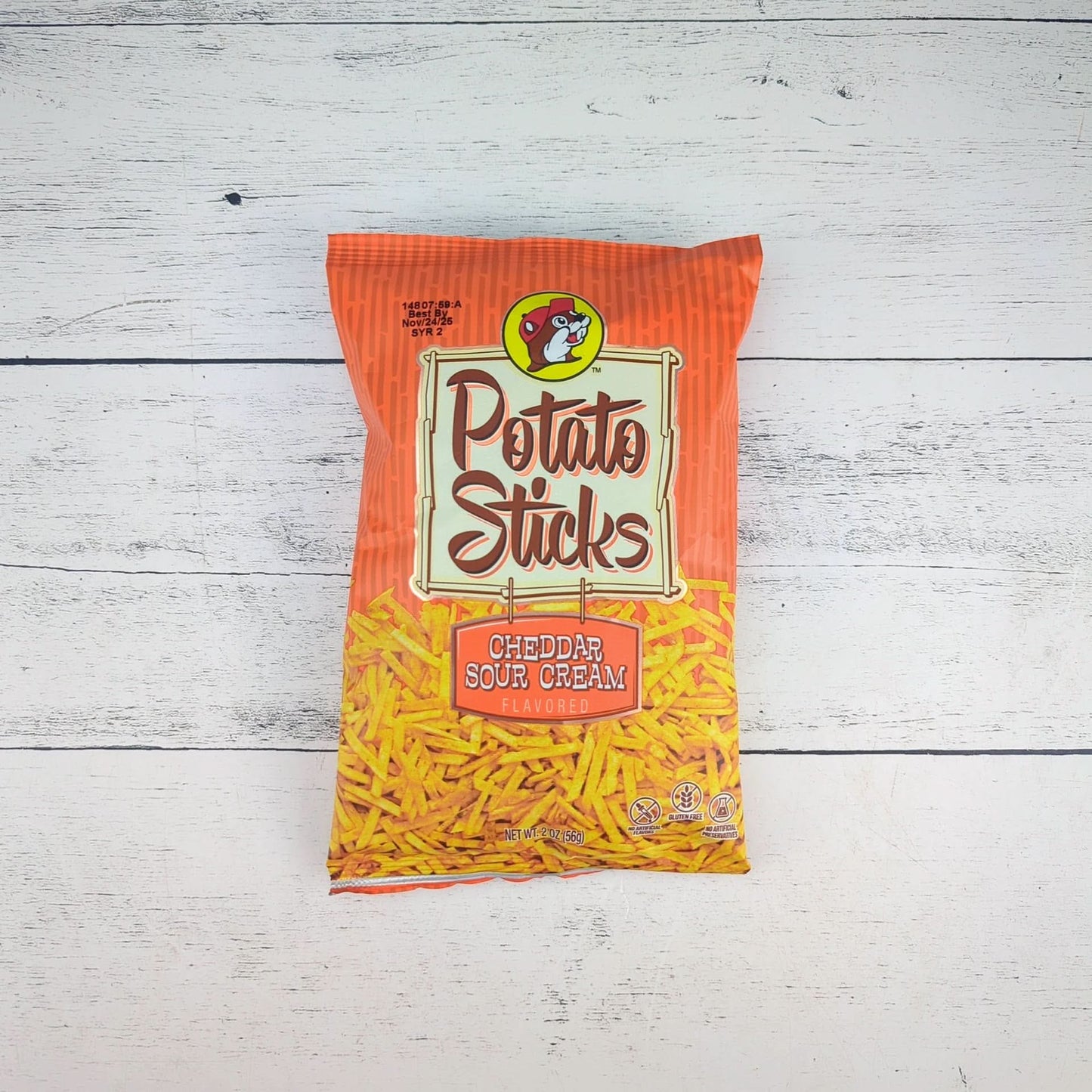 an orange bag of bucees potato sticks cheddar and sour cream flavored, available for inclusion in a texas-themed gift basket, box, or tote