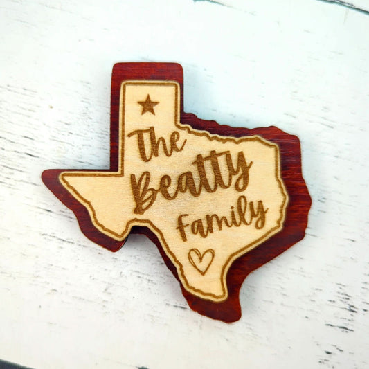 a double layered personalized magnet in the shape of texas with a custom engraved family name
