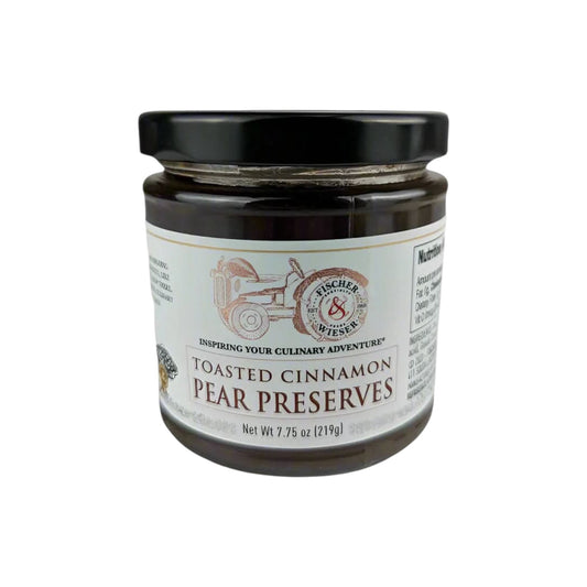 Jar of Fischer & Wieser Toasted Cinnamon Pear Preserves with a black lid and vintage-style label, filled with dark pear preserves, photographed on a white background