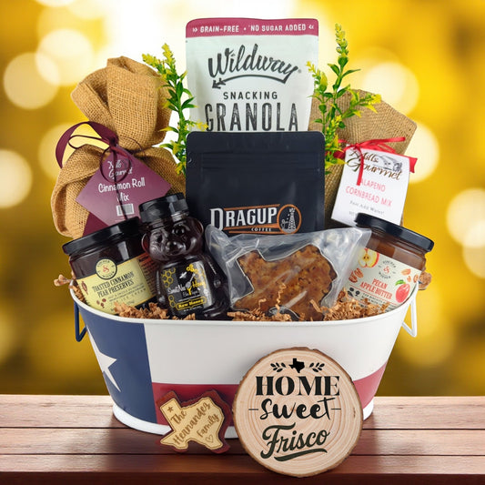 Frisco Morning Breakfast Basket with rustic background, Texas-themed tin filled with pecan coffee, cinnamon roll mix, jalapeño cornbread mix, granola, honey, praline, and preserves.