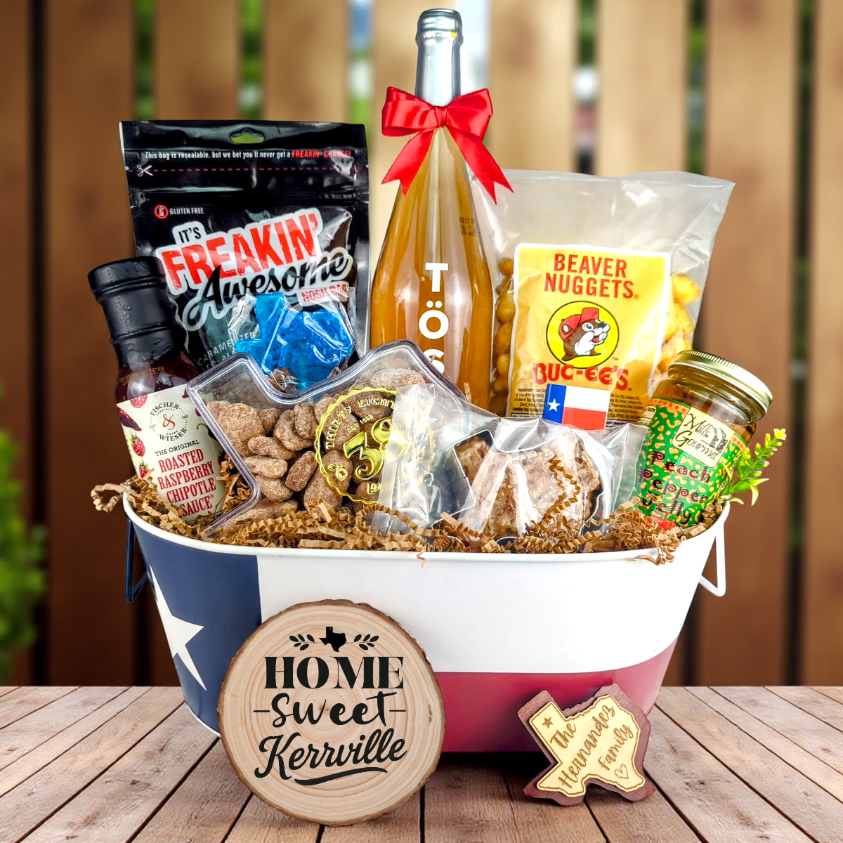 Kerrville Texas Home Toast & Treats basket with TÖST ROSÉ, Peach Pepper Jelly, Buc-ee’s Beaver Nuggets, Texas pecans, praline, chipotle sauce, and Texas flag tin