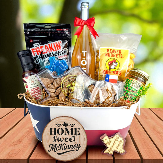 McKinney Texas Family Home Toast & Treats basket with TÖST ROSÉ, Peach Pepper Jelly, Buc-ee’s Beaver Nuggets, Texas pecans, praline, chipotle sauce, and Texas flag tin