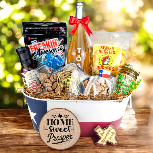 Prosper Texas Home Toast & Treats basket with TÖST ROSÉ, Peach Pepper Jelly, Buc-ee’s Beaver Nuggets, Texas pecans, praline, chipotle sauce, and Texas flag tin