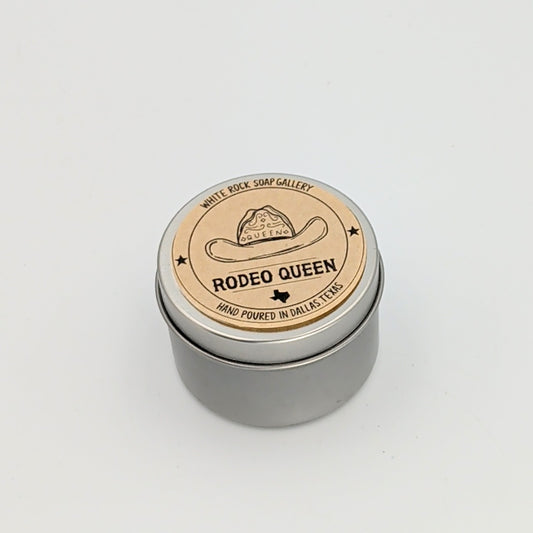 Silver metal candle tin labeled “Rodeo Queen” featuring a cowboy hat illustration, hand poured in Dallas, Texas, displayed on a white background.