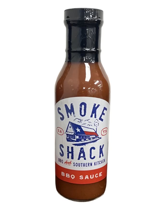 Smoke Shack BBQ Sauce in a sleek bottle, showcasing its smoky Texas flavor, placed on a wooden surface as part of a Texas gift collection.