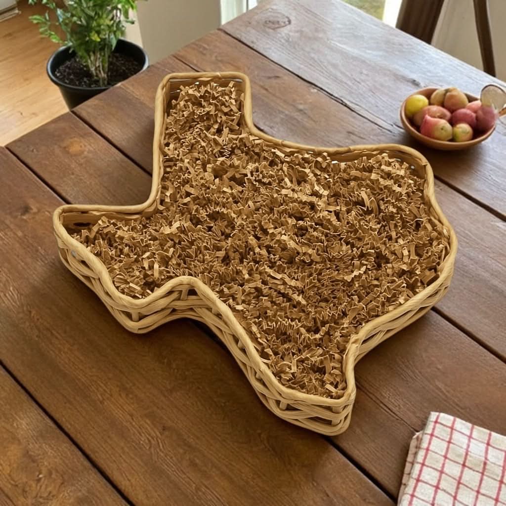 A large willow basket in the shape of Texas, filled with shred paper and ready to be filled with Texas-made products