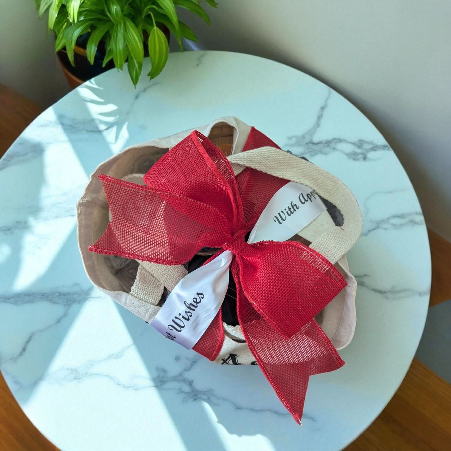 view from the top of a texas tote gift, with a large red bow and custom printed ribbon, sitting on a marble table