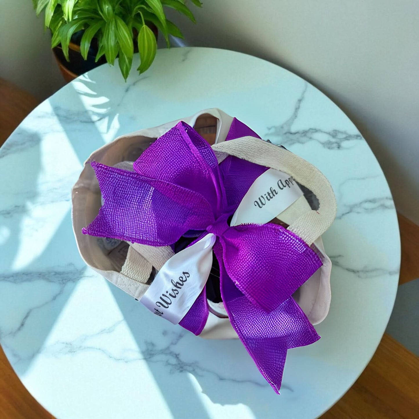 a texas gift tote viewed from the top with a big purple ribbon and printed ribbon on a marble table