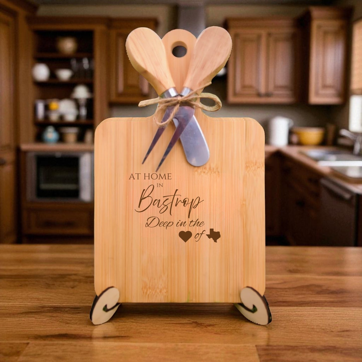 The At Home in Bastrop Charcuterie Board with laser-engraved Texas silhouette and “At Home in Bastrop” text, displayed in a cozy kitchen, ideal for entertaining and Texas pride.