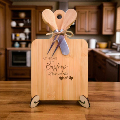 The At Home in Bastrop Charcuterie Board with laser-engraved Texas silhouette and “At Home in Bastrop” text, displayed in a cozy kitchen, ideal for entertaining and Texas pride.