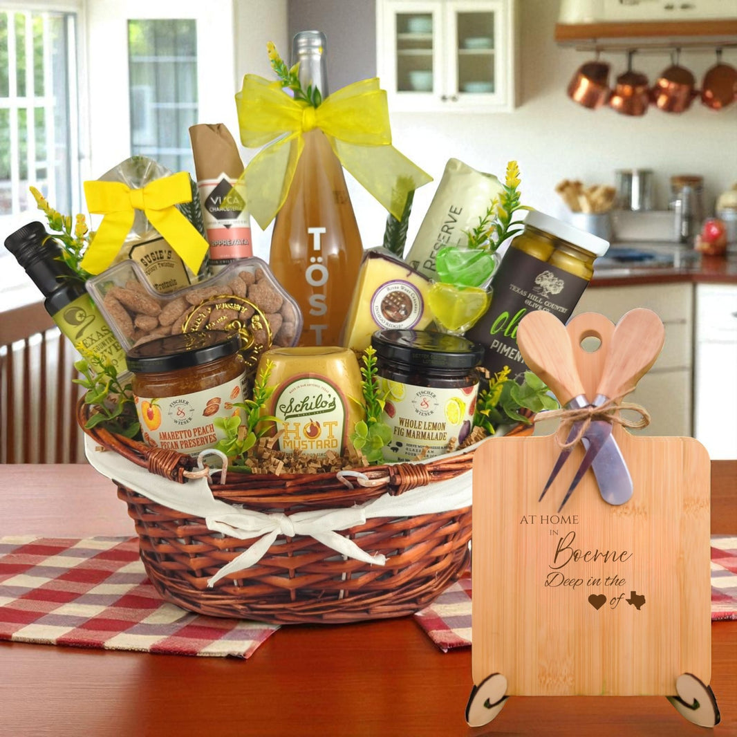 A gourmet gift basket paired with the At Home in Boerne Charcuterie Board, featuring bamboo wood, rustic utensils, and engraved Texas design, perfect for celebrating Boerne’s charm and hospitality.