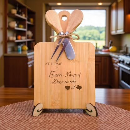 The At Home in Flower Mound Charcuterie Board with laser-engraved Texas silhouette and “At Home in Flower Mound” text, displayed in a cozy kitchen, ideal for entertaining and Texas pride.