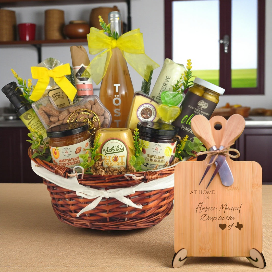 A gourmet gift basket paired with the At Home in Flower Mound Charcuterie Board, featuring bamboo wood, rustic utensils, and engraved Texas design, perfect for celebrating Flower Mound’s welcoming spirit.