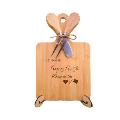 Elegant bamboo charcuterie board with utensils, engraved with “At Home in Corpus Christi, Deep in the Heart of Texas.”