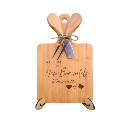 Elegant bamboo charcuterie board with utensils, engraved with “At Home in New Braunfels, Deep in the Heart of Texas.”