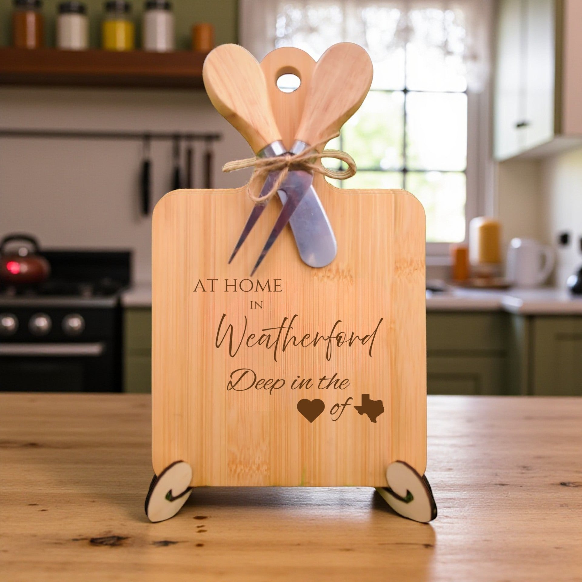 Bamboo charcuterie board engraved with “At Home in Weatherford, Deep in the Heart of Texas” displayed in a kitchen setting.
