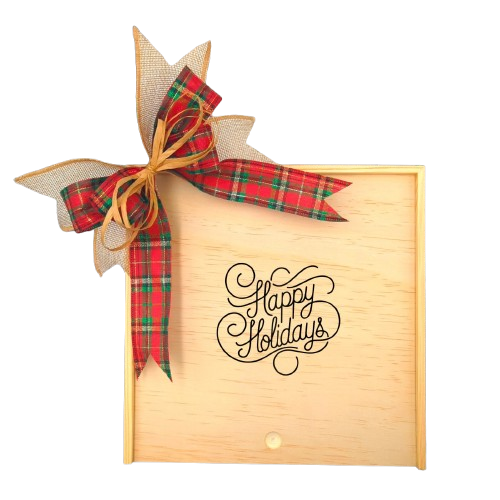 Create Your Own Happy Holidays Wooden Gift Box with a festive plaid ribbon and "Happy Holidays" design, surrounded by holiday greenery, cinnamon sticks, and seasonal decorations.