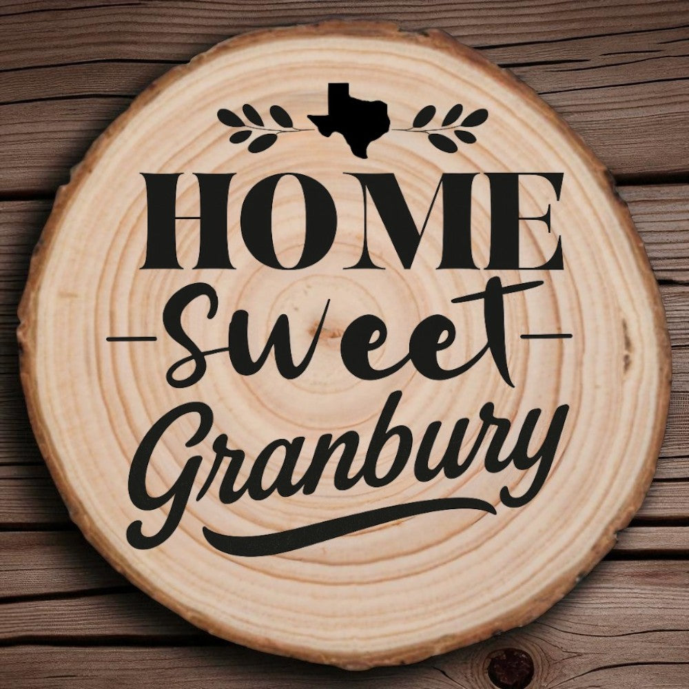 Rustic wood slice coaster with “Home Sweet Granbury” laser engraving, Texas silhouette, and leafy accents on wood background.