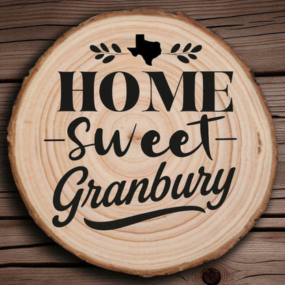 Rustic wood slice coaster with “Home Sweet Granbury” laser engraving, Texas silhouette, and leafy accents on wood background.