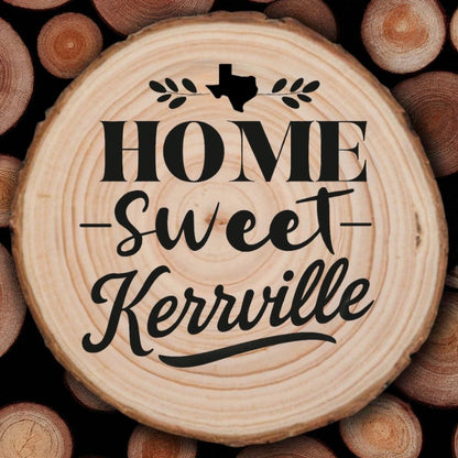 Rustic wood slice coaster with “Home Sweet Kerrville” laser engraving, Texas silhouette, and leafy accents on wood background.