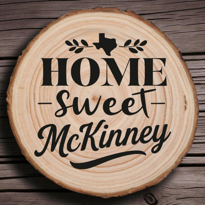 Rustic wood slice coaster with “Home Sweet McKinney” laser engraving, Texas silhouette, and leafy accents on wood background.