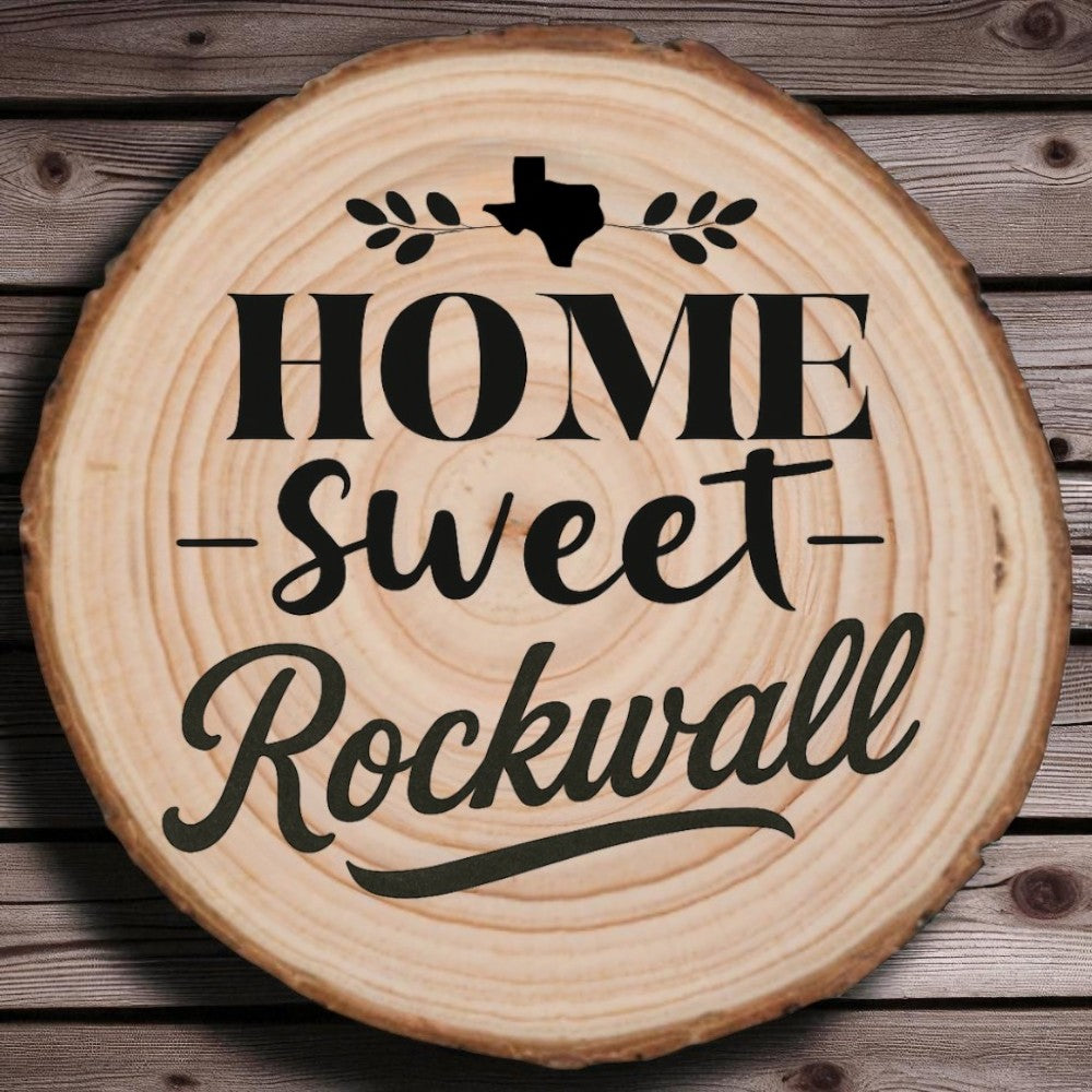 Rustic wood slice coaster with “Home Sweet Rockwall” laser engraving, Texas silhouette, and leafy accents on wood background