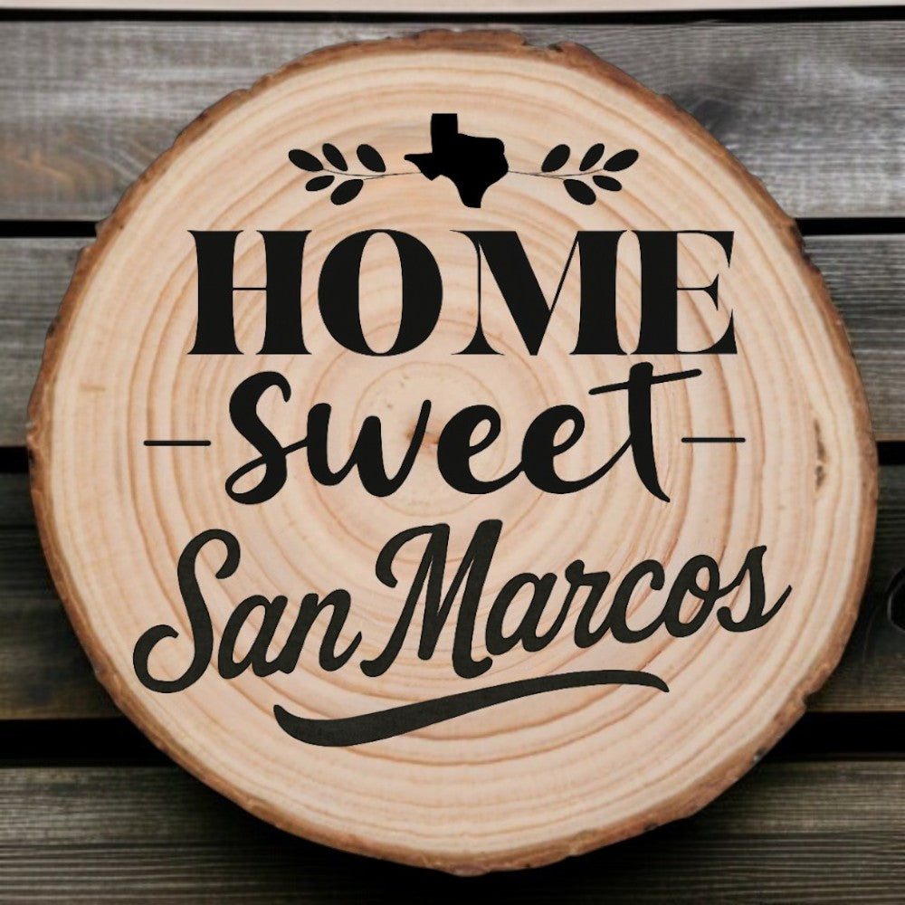 wood slice coaster with “Home Sweet San Marcos” laser engraving, Texas silhouette, and leafy accents on wood background