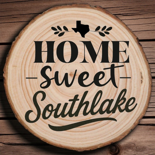 Rustic wood slice coaster with “Home Sweet Southlake” laser engraving, Texas silhouette, and leafy accents on wood background.