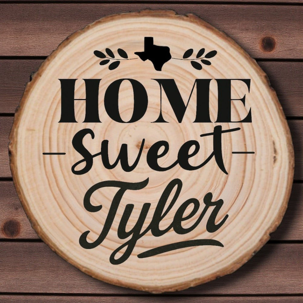Rustic wood slice coaster with “Home Sweet Tyler” laser engraving, Texas silhouette, and leafy accents on wood background.