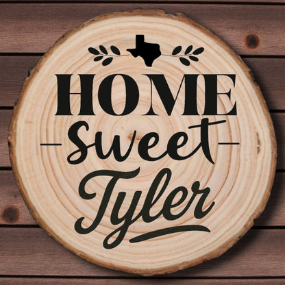 Rustic wood slice coaster with “Home Sweet Tyler” laser engraving, Texas silhouette, and leafy accents on wood background.