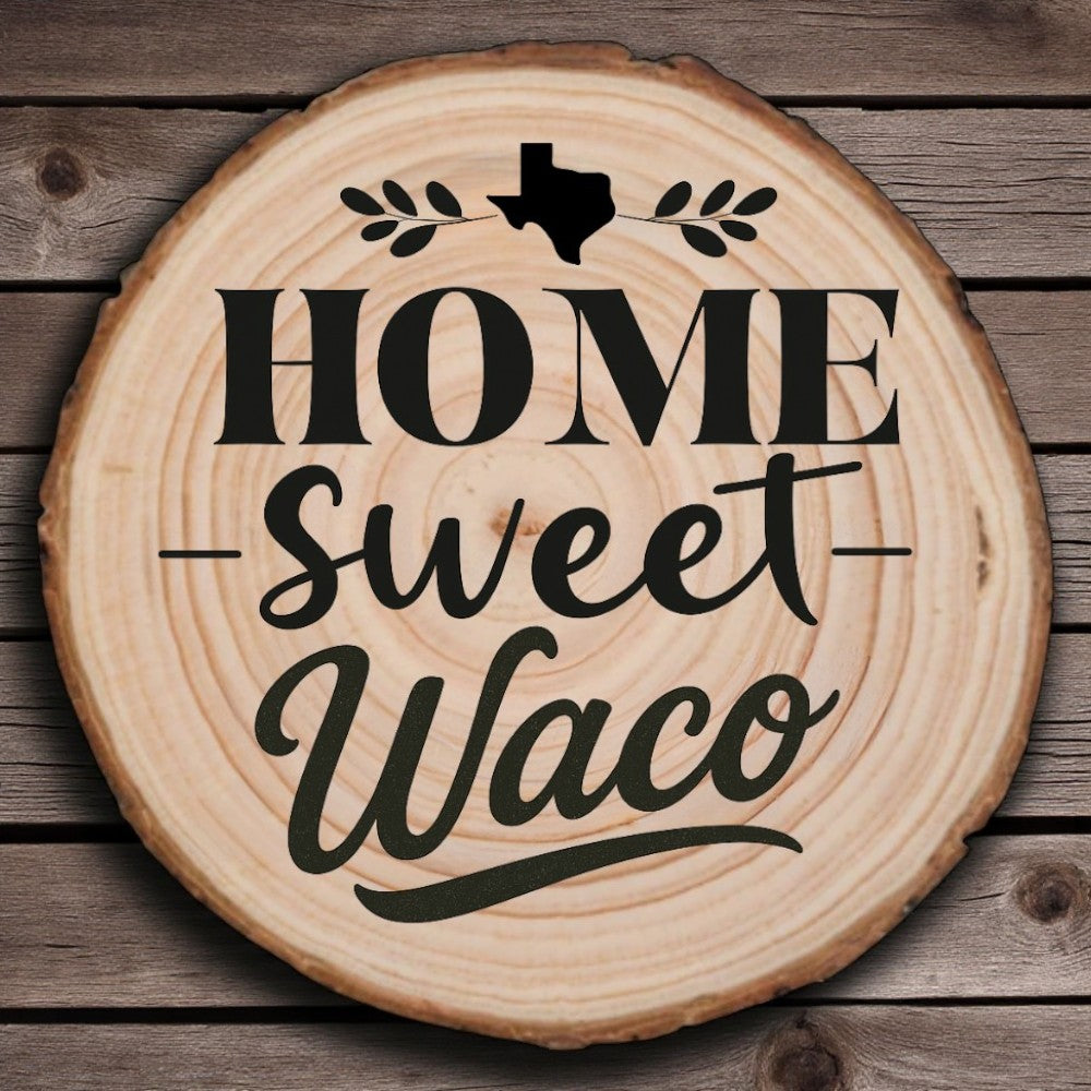 Rustic wood slice coaster with “Home Sweet Waco” laser engraving, Texas silhouette, and leafy accents on wood background.