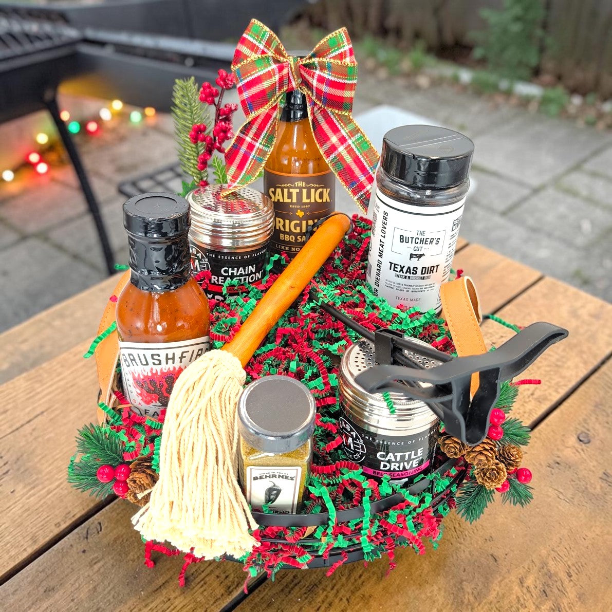 A Texas Pitmaster Christmas BBQ gift in the Texas Homestead Handle Tray with Christmas ribbon and red and green shred.