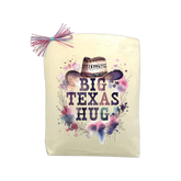 Big Texas Hug Cowgirl Edition gift tote with floral cowgirl hat design, isolated on a black background for product display.