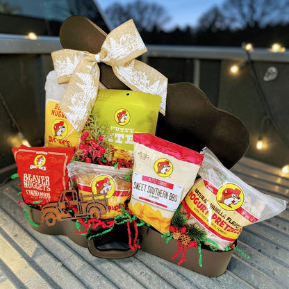Buc-ee’s Christmas Road Trip gift with six snacks and a Texas truck magnet in a guitar case with Christmas ribbon.