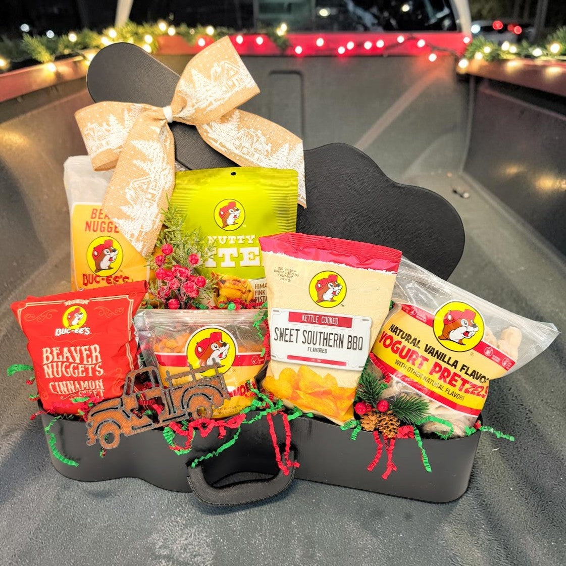 Second view of Buc-ee’s Christmas Road Trip guitar case gift with festive ribbon, six snacks and a Texas pickup truck magnet.