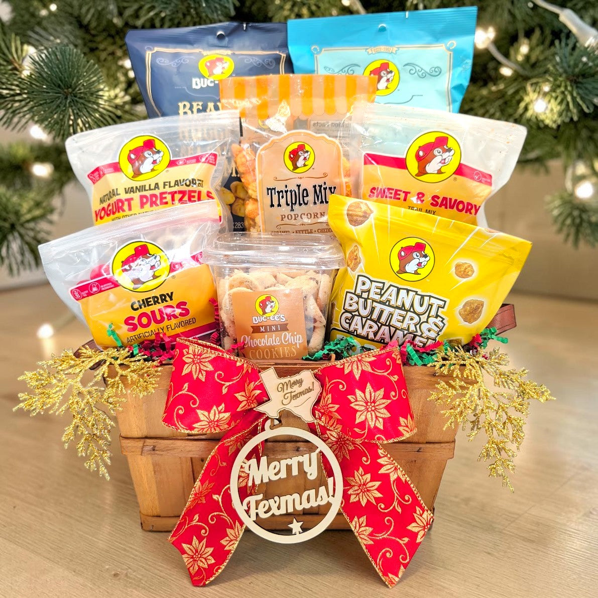Front view of Buc-ee’s Texmas Munch Basket with eight snacks, poinsettia bow and Merry Texmas wooden decorations