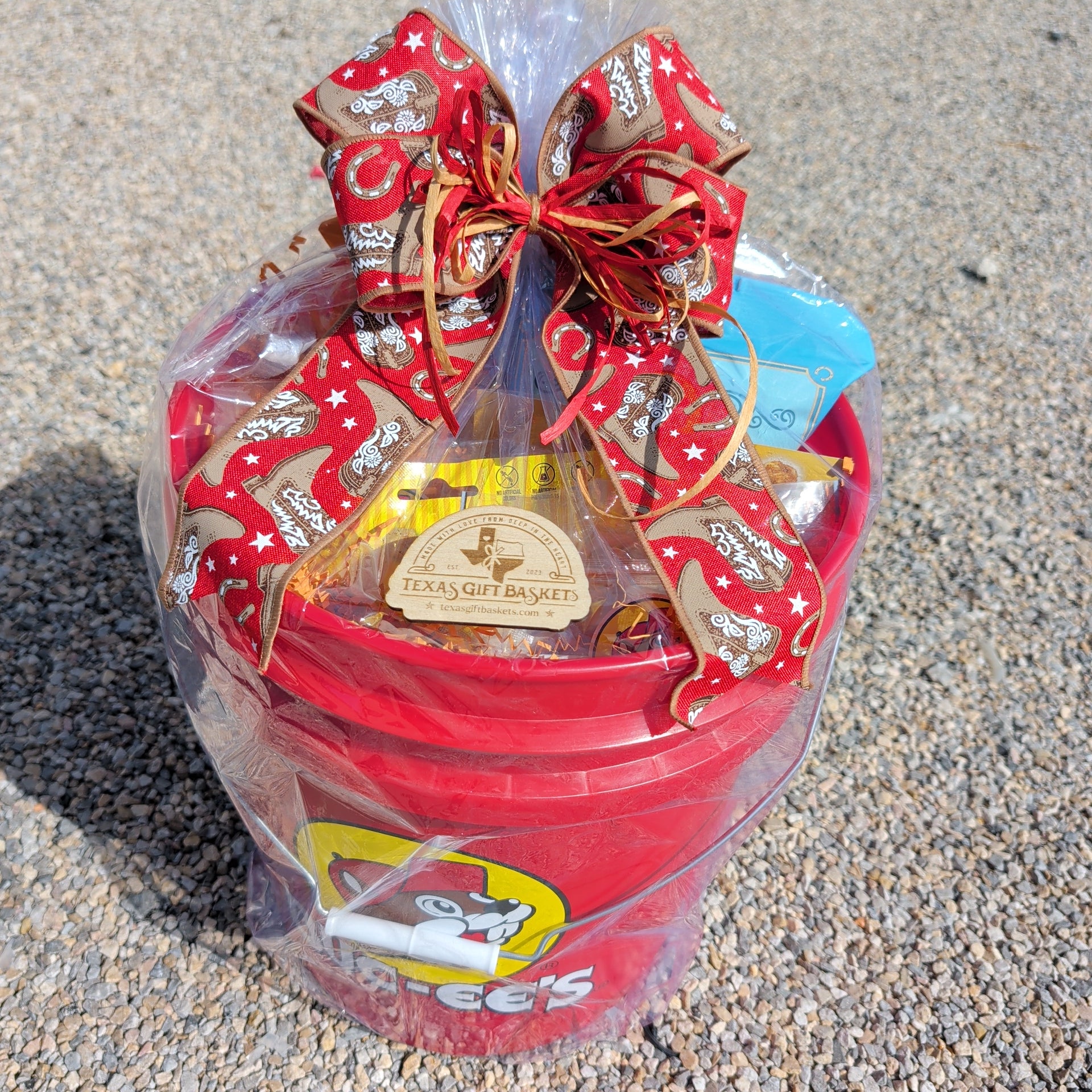 a red bucees themed gift bucket filled with bucees snacks