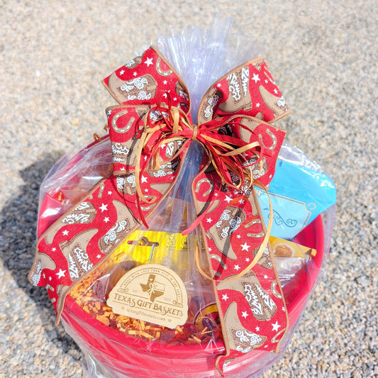 a big red 5 gallon bucket filled with snacks and goods from buc-ee's 