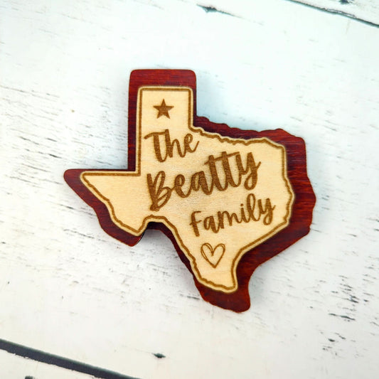 a double layered personalized magnet in the shape of texas with a custom engraved family name