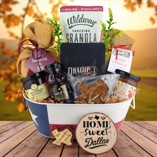 Dallas Texas Breakfast Basket with rustic background, Texas-themed tin filled with pecan coffee, cinnamon roll mix, jalapeño cornbread mix, granola, honey, praline, and preserves.